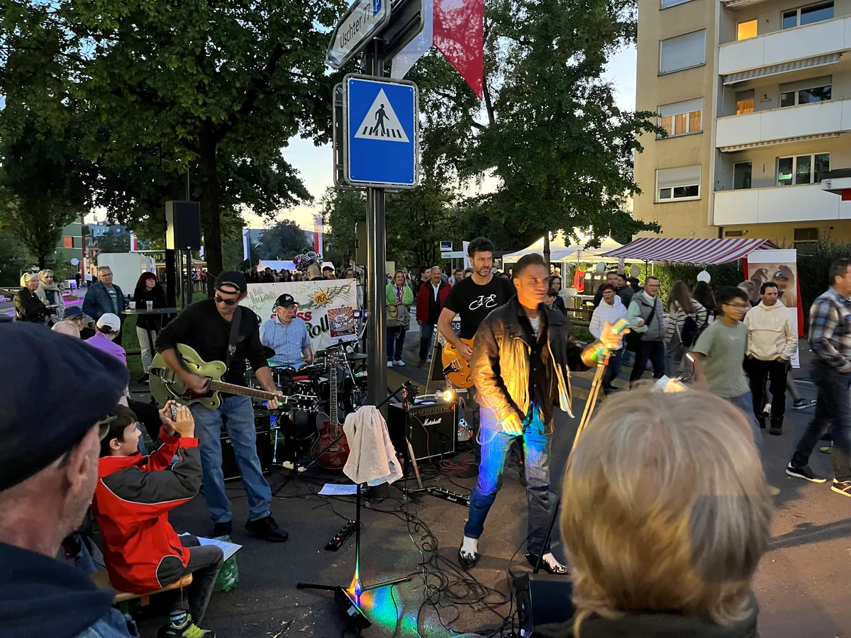 Musik ist ein wichtiger Bestandteil des Stadtfests. Zum Teil spielen die Bands mitten in der Menge. Ein Mann mit Mikrofon singt in einer Menschenmenge.